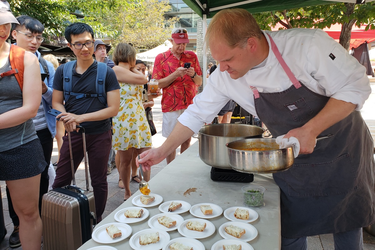 Amos_watts_farmers_market_2018_by_covington white chef plating food outside