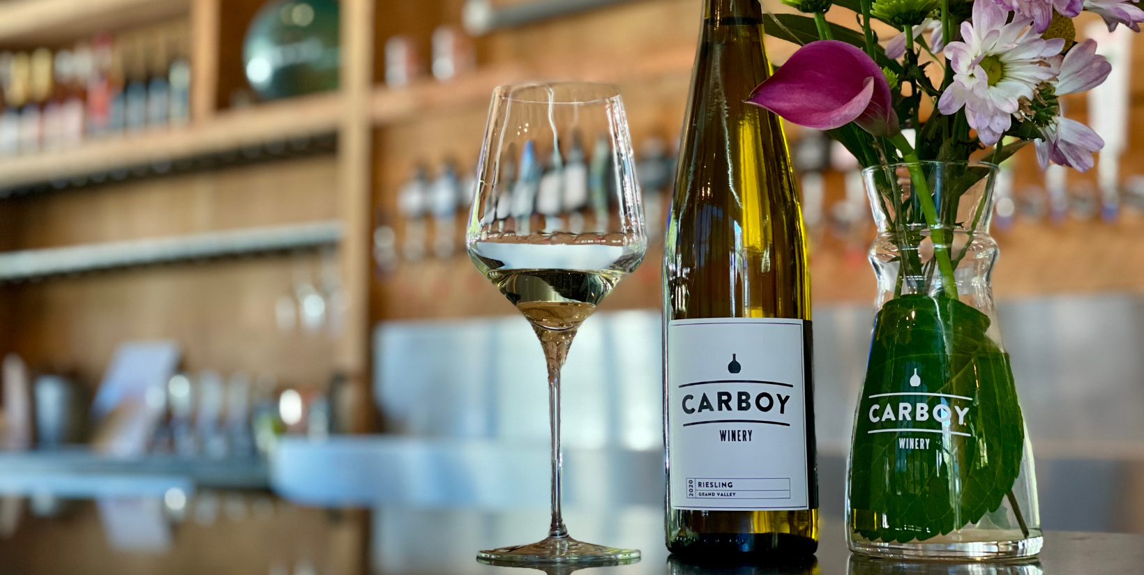 Like many people having their eyes opened to the exciting changes in the Colorado wine scene, I got my introduction from the team at Carboy. As Colorado’s fastest-growing winery, the crew has accomplished a lot in a short amount of time.
The flagship winery and tasting room opened in Littleton back in 2016. Over the years, the company added tasting rooms in Denver’s Capitol Hill neighborhood and Main Street in Breckenridge. In 2022, Carboy opened its new facility in Palisade at Mt. Garfield Estate. The vineyards at the base of the plateau are breathtaking, offering special events and tastings throughout the season. Wherever you are in Colorado, there are opportunities to enjoy this pioneering brand.