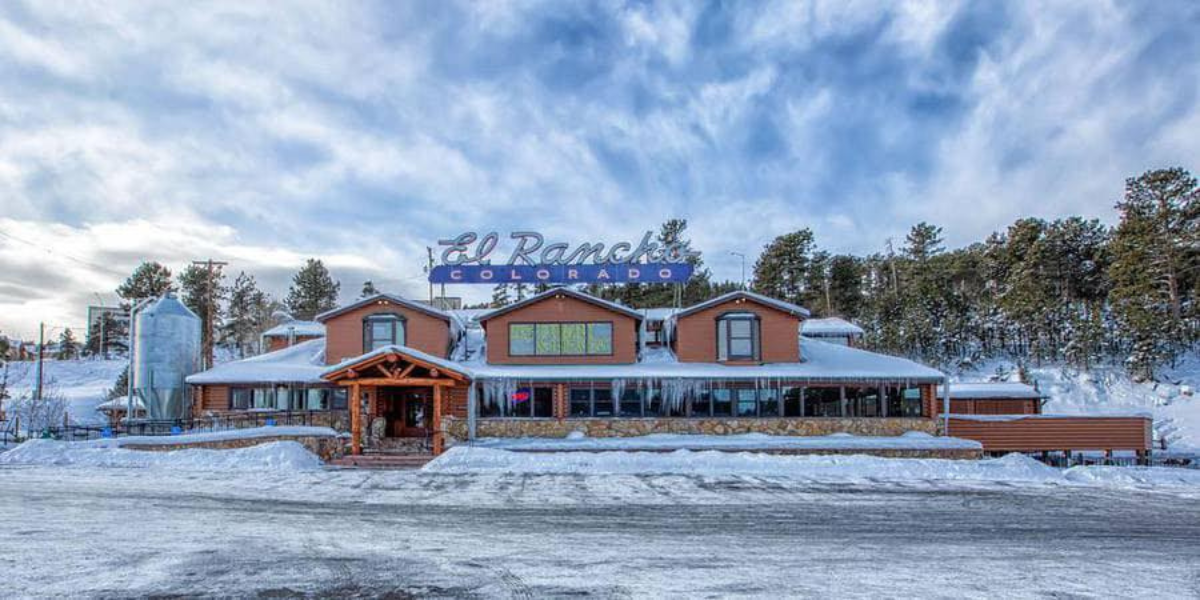 A snowy scene on a sunny day at El Rancho Restaurant and Brewery in Evergreen, Colorado