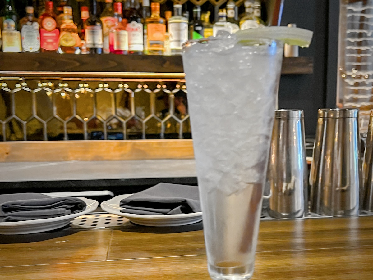 clear cocktail with bar behind it