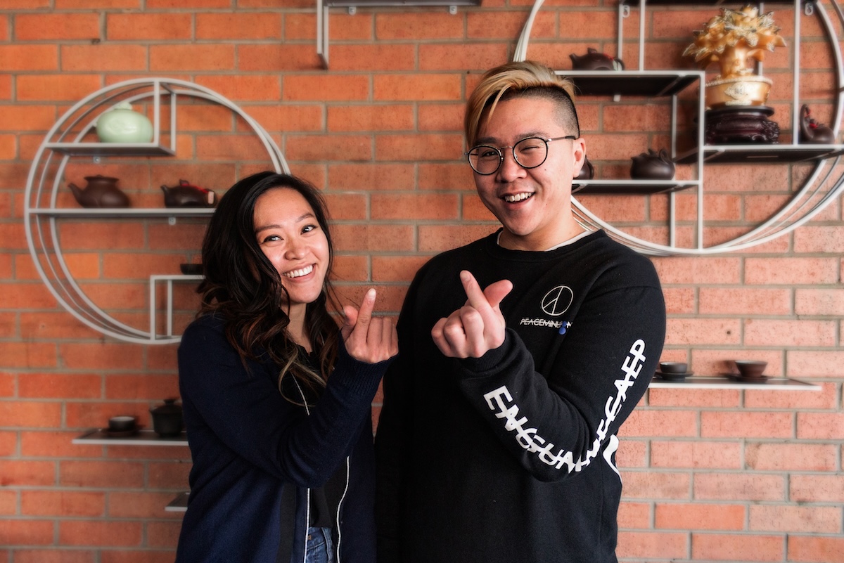 Patrick-and-Victoria-Tea-Street-by-Alex-Guardia brick wall with two asian people standing in front
