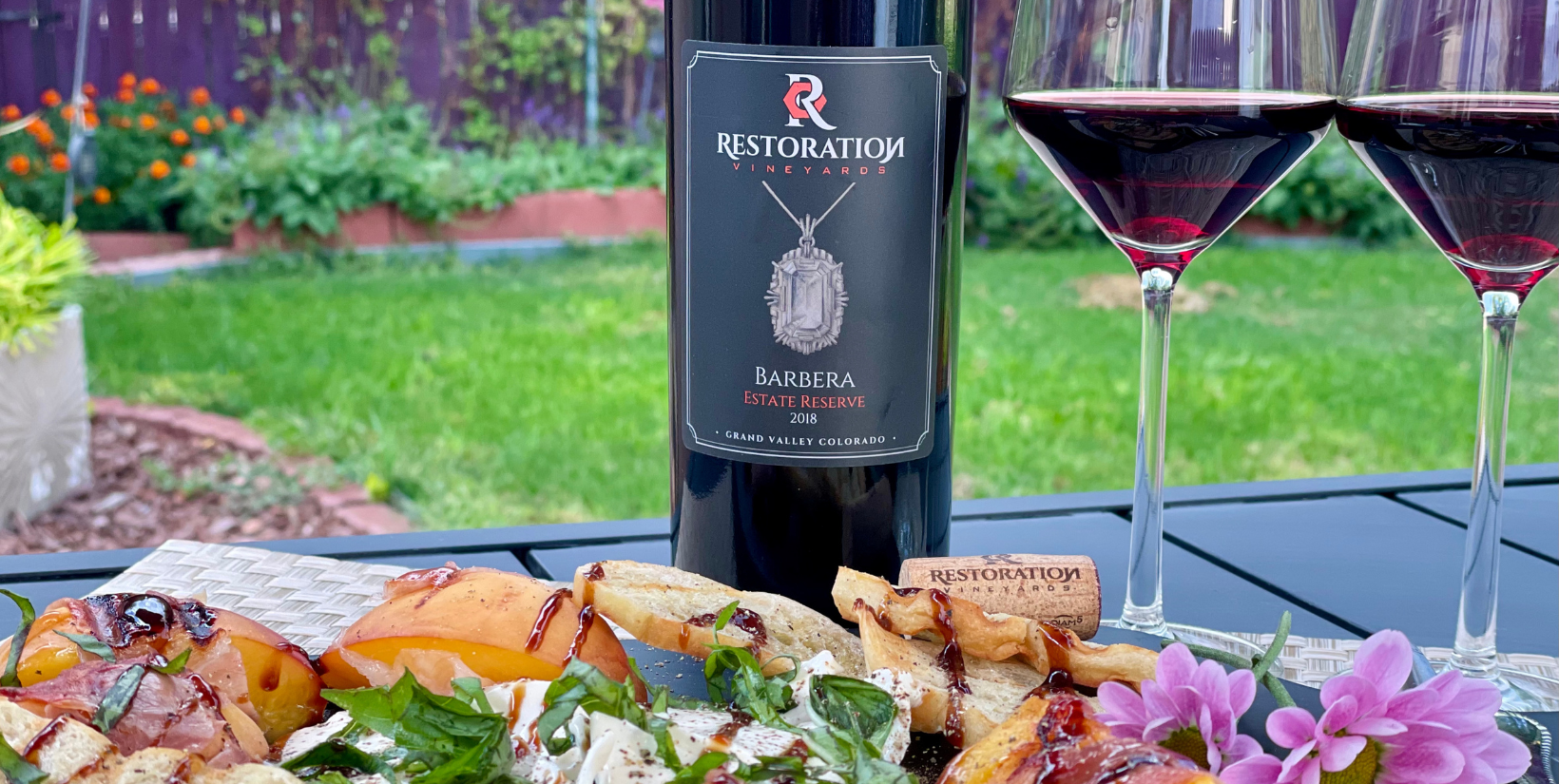 Restoration has been family-owned and operated since 2012 when the Brauns purchased a vineyard plot and farmhouse in Palisade in desperate need of, well, restoration. Enamored by the natural beauty and community of the area, they brought the vines back to life, eventually releasing their wines.
Today, the grounds feature a sprawling lawn with sitting areas, yard games, and live music. Food trucks often pull up on the weekends, and one can easily spend an afternoon sipping on the wines and making new friends. My personal favorite is the Estate Reserve Barbera. It’s tart yet easy on the palate with bright red fruit flavors and baking spice.