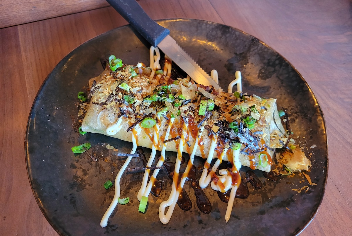 black plate with burrito and knife
