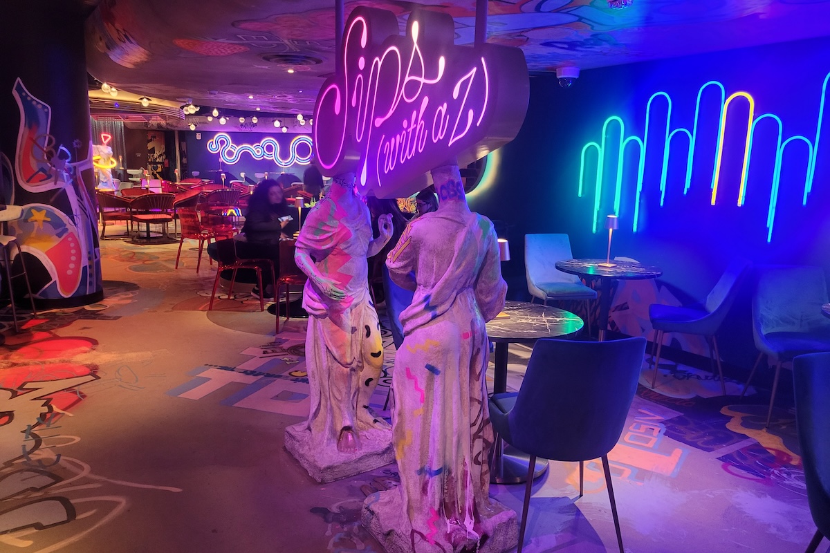 white statues with neon sign and purple room