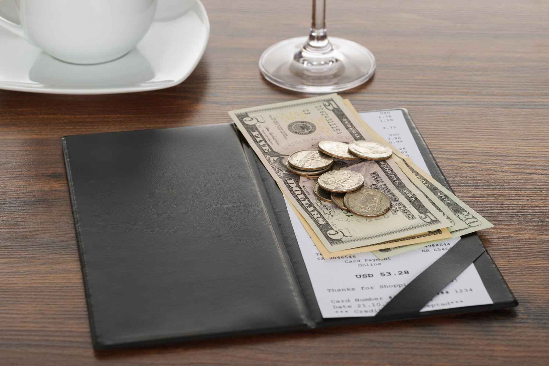 Dollar bills and change left on a restaurant table as a tip.