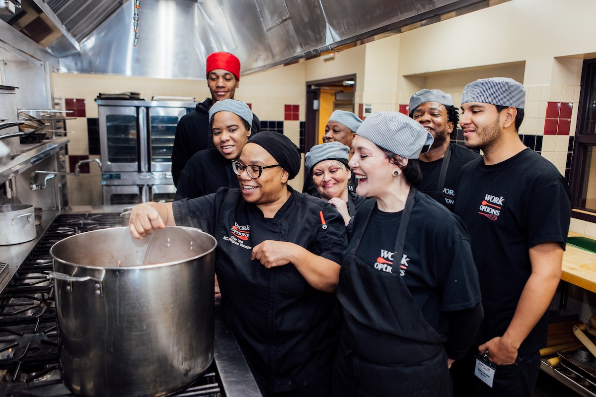 work_options_stove Students gather around the stove to learn and take in the culinary arts. | Photo by Work Options
