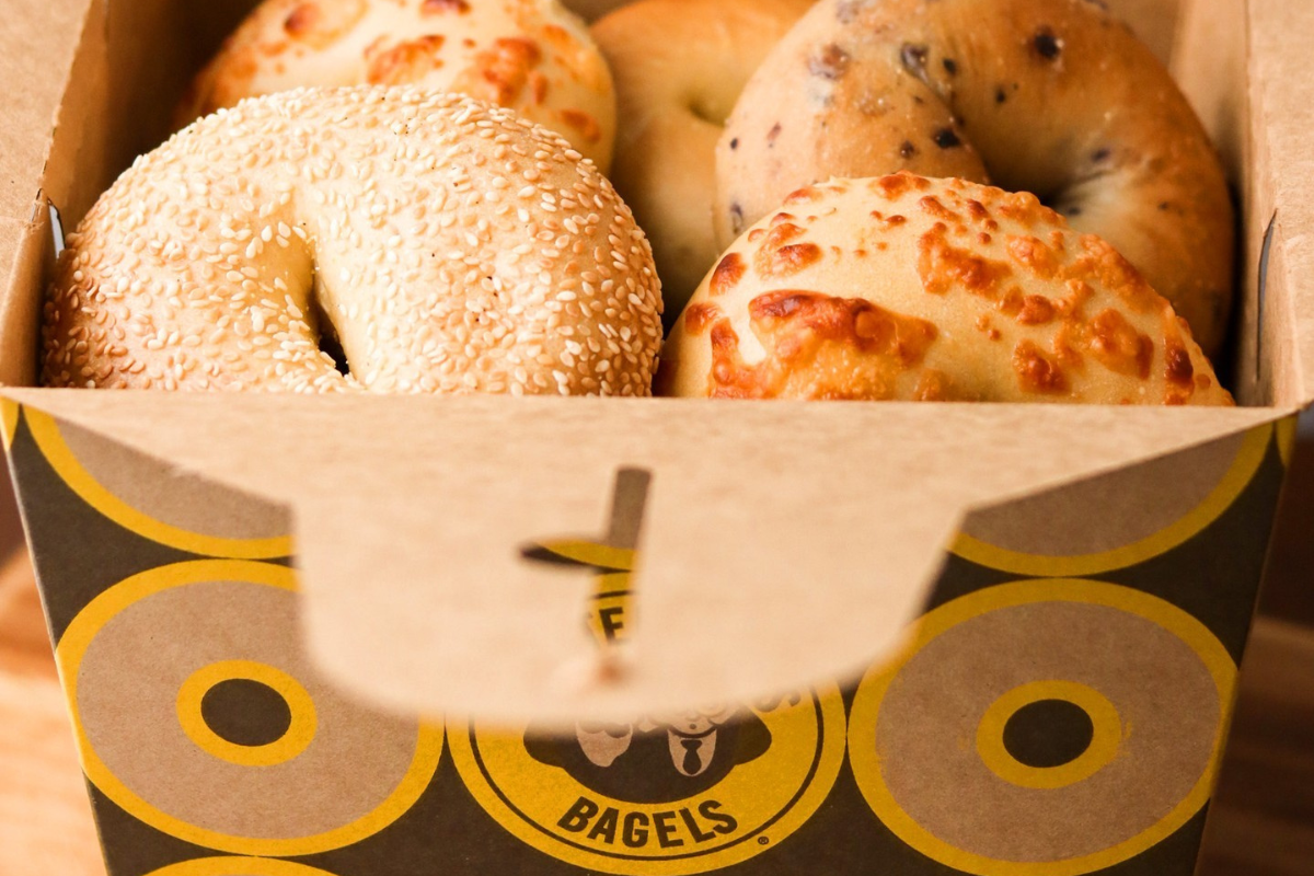 einstein bros bagels A close-up of a takeaway box from Einstein Bros. Bagels filled with a variety of fresh bagels, including sesame, cheese, and chocolate chip.