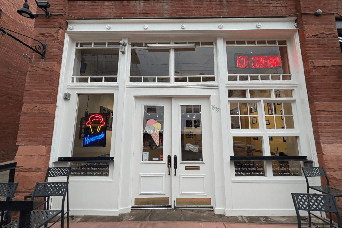 inside scoop creamery Inside Scoop Creamery storefront in Denver with neon ice cream signs, brick exterior, white doors, and patio seating.