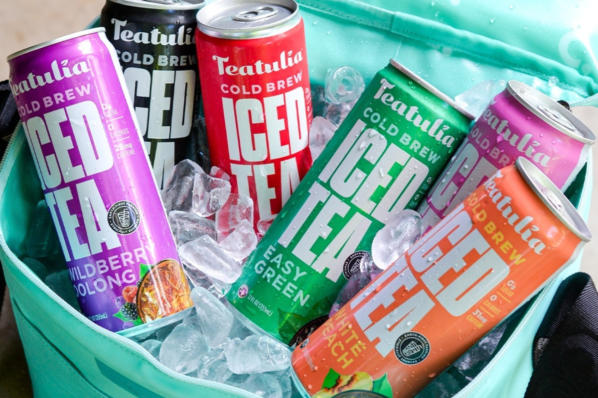 teatulia tea coffee bar Teatulia cold brew iced teas in colorful cans packed in ice inside a teal cooler, featuring flavors like wildberry oolong and white peach.