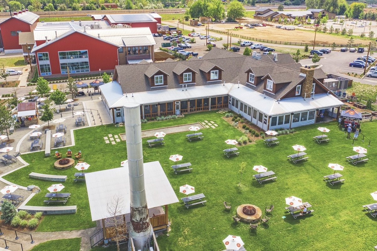 Breckenridge_Brewery Aerial view of Breckenridge Brewery in Littleton, Colorado, featuring a spacious beer garden with picnic tables, umbrellas, and outdoor fire pits.