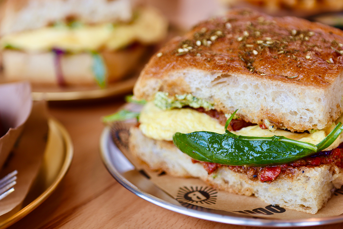 Odie Bs photos courtesy of Hard Knoch PR Odie B's breakfast sandwich features fluffy eggs, herbed spread, sun-dried tomatoes, and a whole green chile on thick focaccia bread.