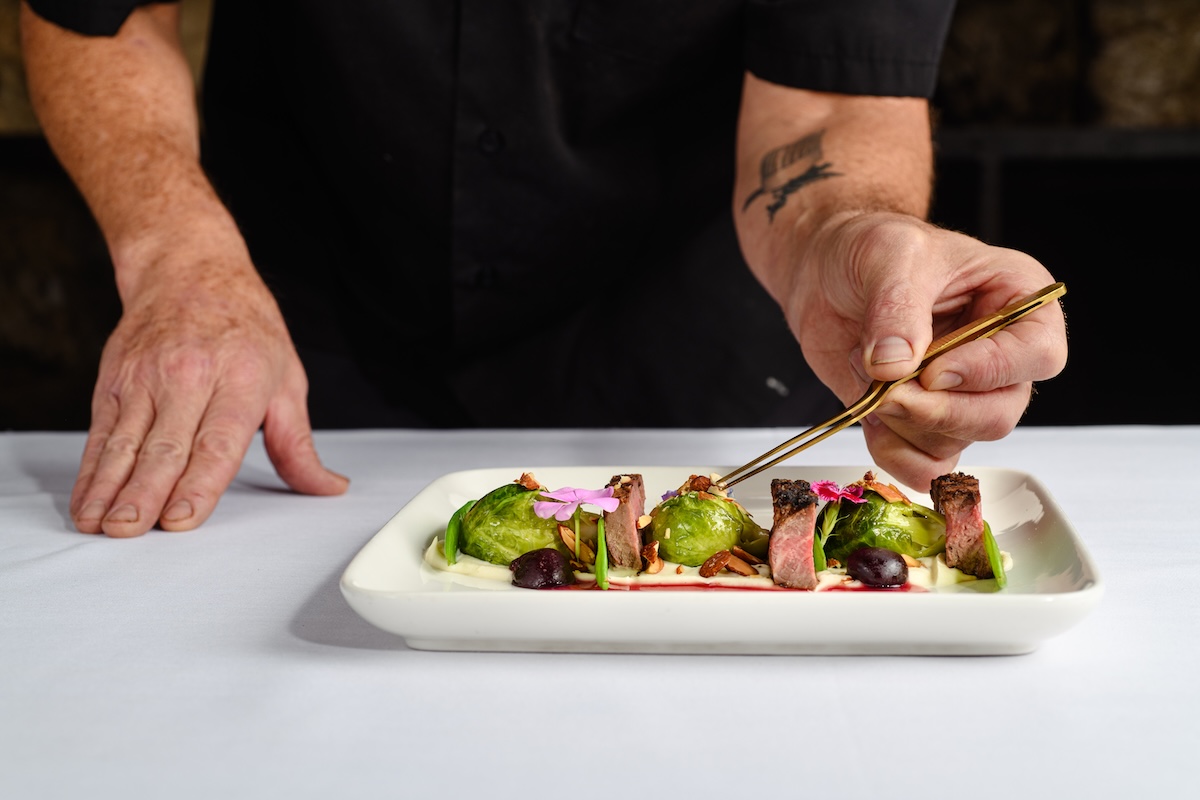Chef Rand Packer plating a dish at his fine-dining restaurant in Evergreen. | Photo by Evoke 1923