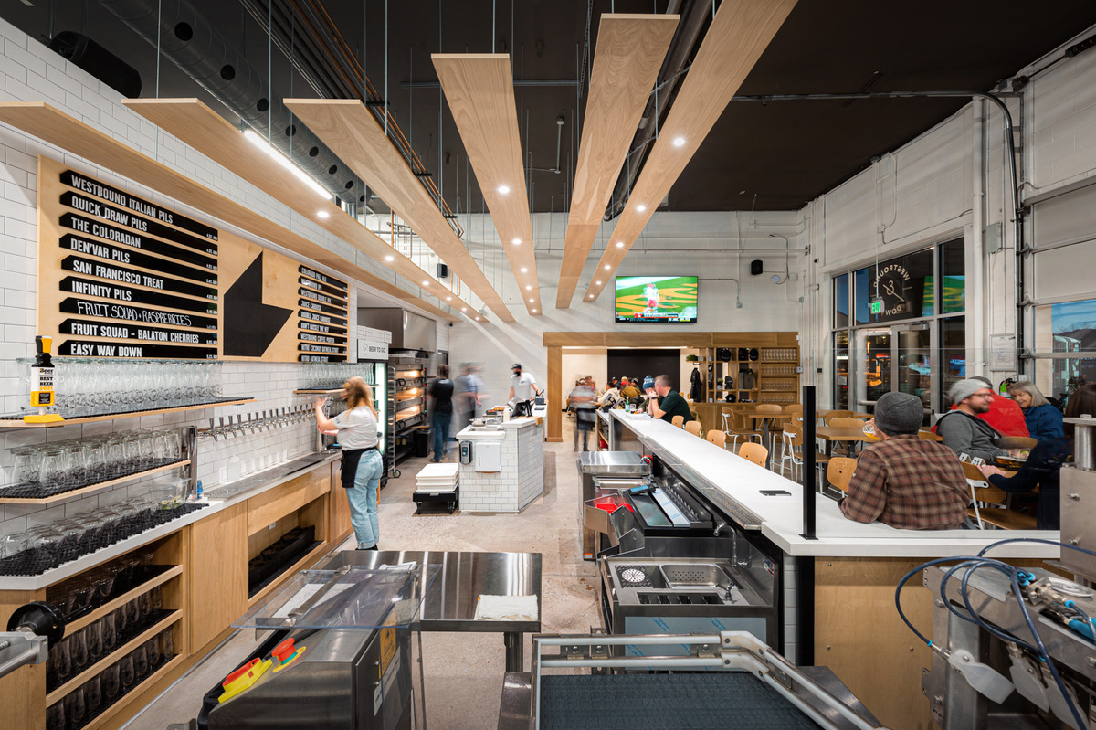 Westbound__Down_Brewing_Company Interior of Westbound & Down Brewing Company in Colorado, featuring a modern taproom with a long bar, beer menu, open kitchen, and cozy seating.