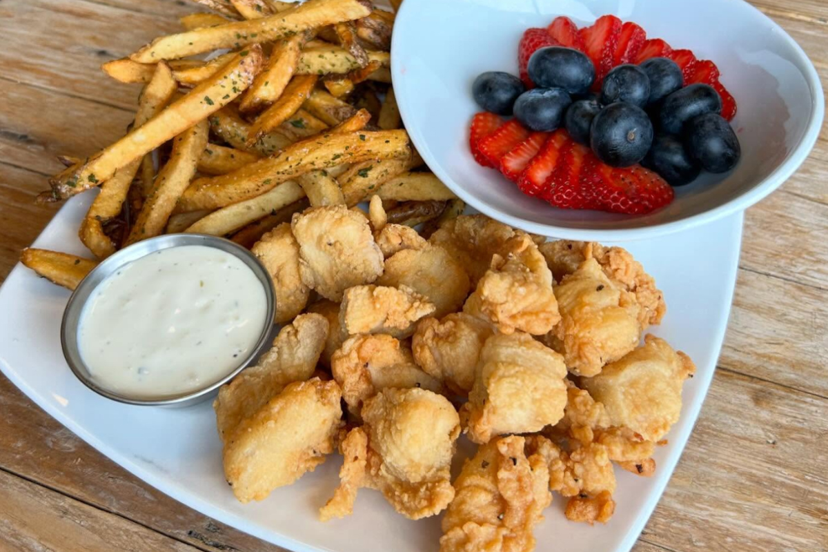johns table Plate of chicken bites with fries, ranch dipping sauce, and a side of fresh strawberries and blueberries at John’s Table in Louisville.