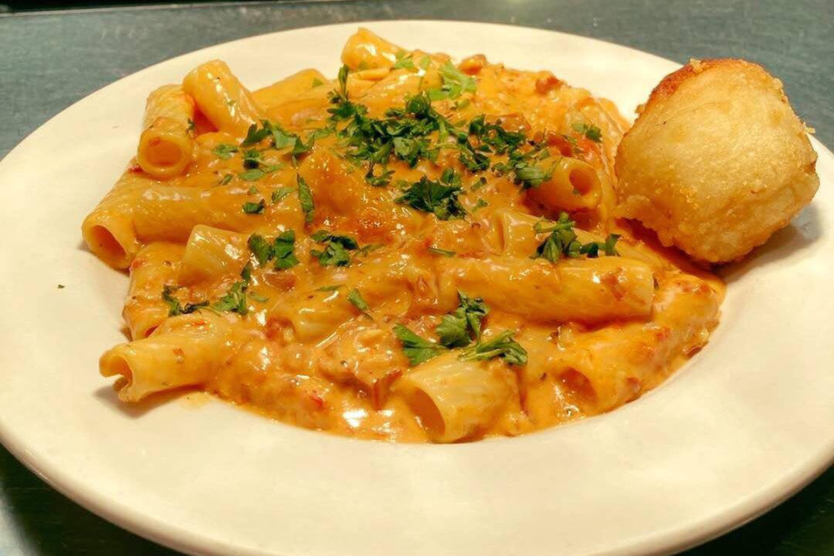 lil riccis ny pizza pasta Rigatoni pasta in creamy tomato sauce topped with parsley and served with a garlic roll at Lil Ricci’s NY Pizza & Pasta in Denver.
