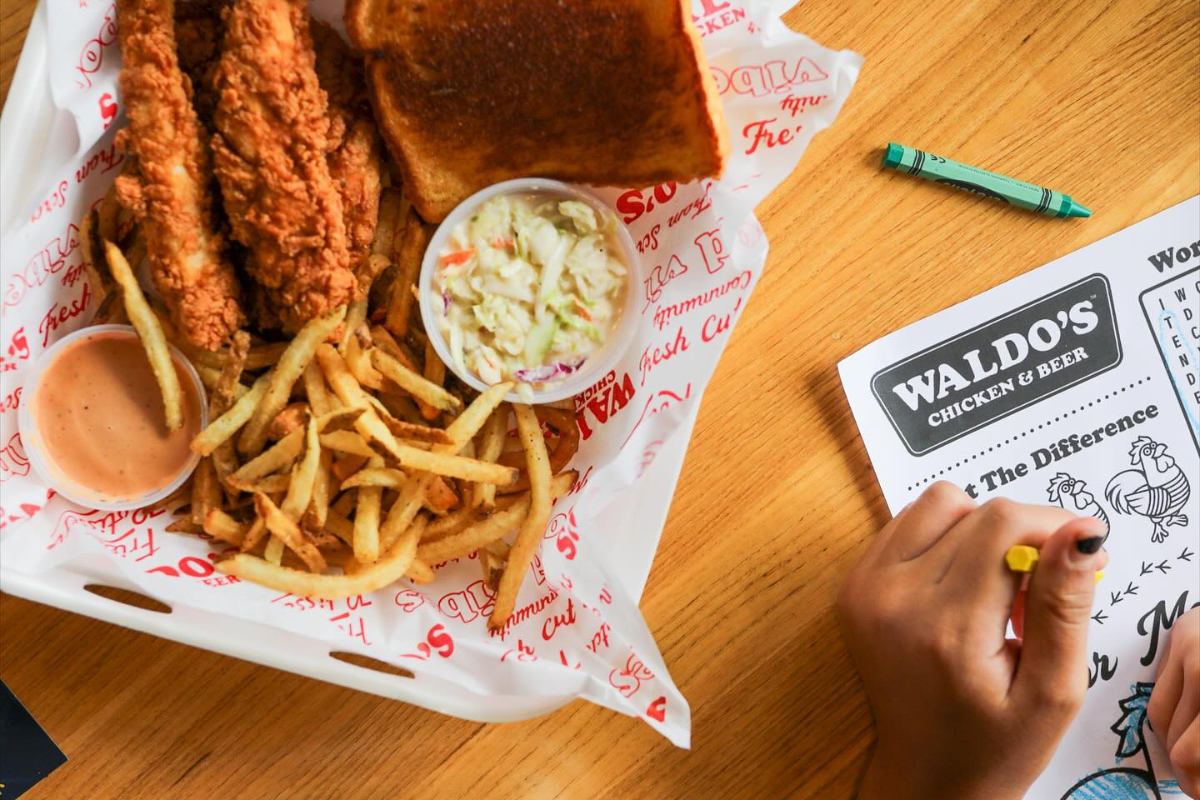 waldos chicken and beer Chicken tenders with mac and cheese and dipping sauce at Waldo’s Chicken & Beer on a red tray.
